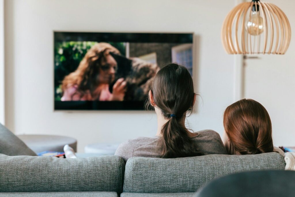 a couple of women sitting on top of a couch